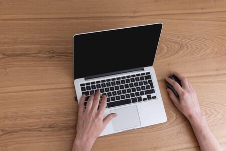 Man working on laptop, top view on male hands using laptopの写真素材