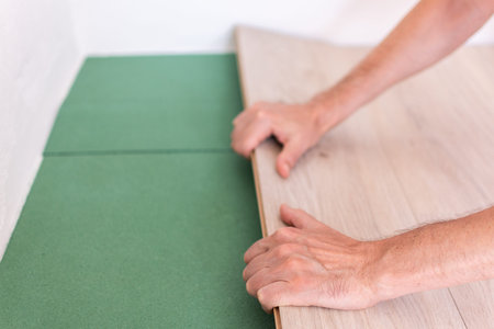 Installation laminate or parquet in the room, worker installing wooden laminate flooring,...