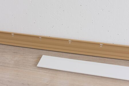 Installing plastic skirting board in the room, repair work in the houseの写真素材