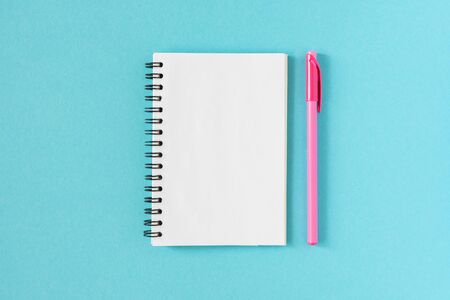 Open spiral notepad on a blue background , notebook and pen lie on textural paper, flat lay conceptの写真素材