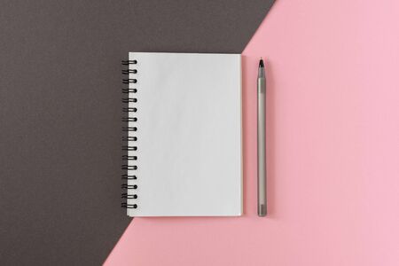 Open spiral notepad on colored background , notebook and pen lie on textural papers, flat lay conceptの写真素材