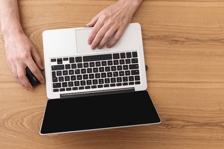 Man working on laptop, top view on male hands using laptopの写真素材