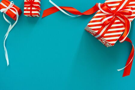 Festive background with gifts, gift box with ribbon and bow on a blue turquoise background, flat lay, top viewの写真素材