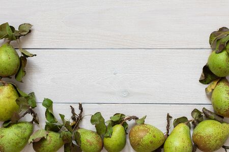 Fresh organic green pears with leaves on a natural white wooden backgroundの写真素材