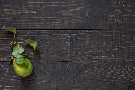 Fresh organic green pear with leaves on a natural brown wooden backgroundの写真素材