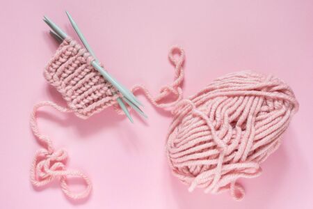 Ball of thread and knitting needles on pink background, start knitting mittensの写真素材