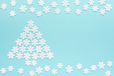 Holiday pastel background, white snowflakes and Christmas tree on a gentle blue background ,flat lay, top viewの写真素材