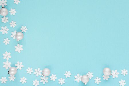 Holiday pastel background, white snowflakes and Christmas ball on a gentle blue background ,flat lay, top viewの写真素材