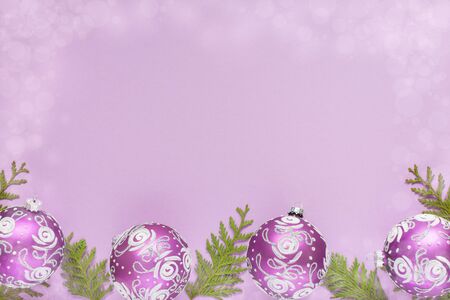 Holiday background , christmas balls and thuja twigs on a lilac background with glitter silver stars, flat lay, top viewの写真素材