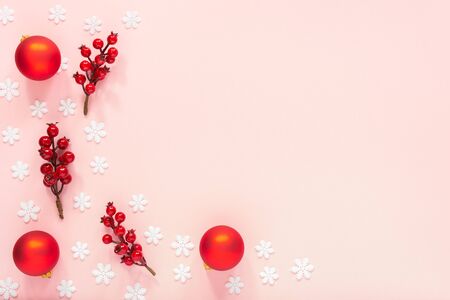 Holiday background , twigs of hawthorn and christmas balls on a pink background with snowflakes , flat lay, top viewの写真素材