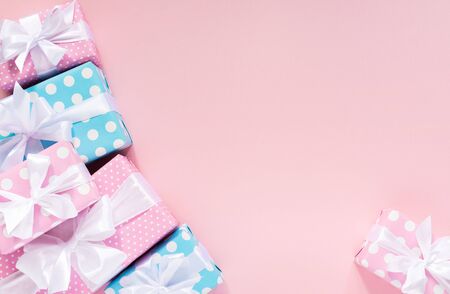 Holiday background , pink and blue gift boxes in polka dots with white ribbon and bow on a pink background , flat lay, top view, birthday or valentines dayの写真素材