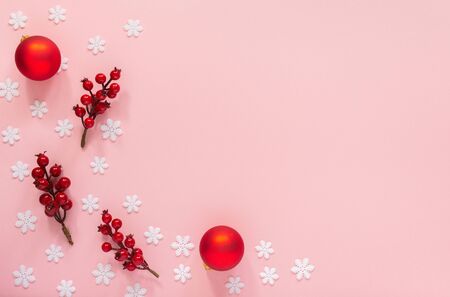 Holiday background , twigs of hawthorn and christmas balls on a pink background with snowflakes , flat lay, top viewの写真素材