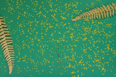 Festive background with decorations , shiny golden fern leaves on a green background with glitter gold stars , flat lay, top view, copy spaceの写真素材