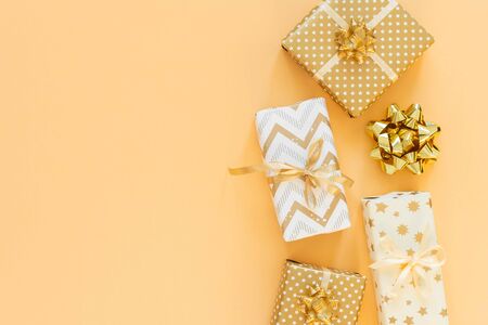 Holiday background in gold colors, gift boxes with bows on a gold background, flat lay, top view, copy spaceの写真素材