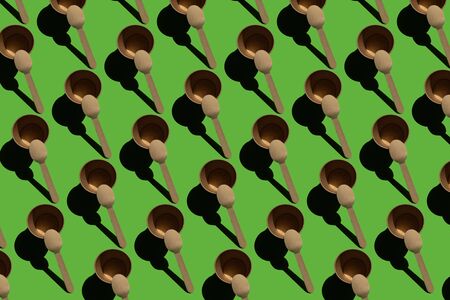 Disposable recyclable tableware eco tableware with hard shadows on a green background, repeating paper cup and spoon patternの写真素材