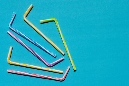 Multi-colored striped tubules for drinks on a blue background, holiday conceptの写真素材