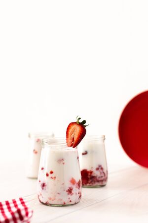 Milkshake with fresh summer strawberries, glass jars with strawberry milkshake, delicious healthy breakfastの写真素材