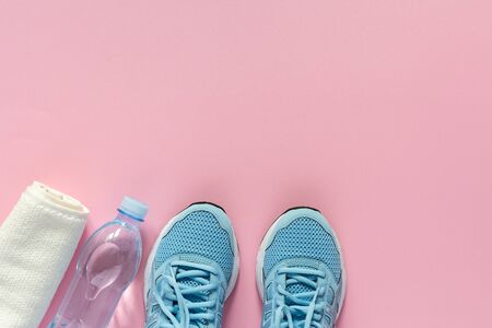 Blue sneakers and a towel with water on a pink background, playing sports or fitness, top view, healthy sport lifestyle conceptの写真素材