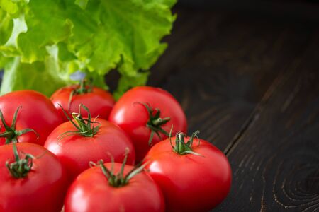 Fresh juicy ripe pink tomatoes with green ponytails, a new crop of organic vegetablesの写真素材