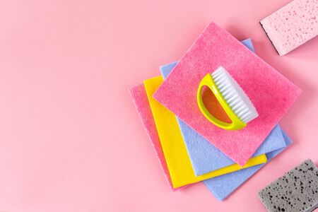 Multi-colored cloths and cleaning sponges on pink backgroundの写真素材
