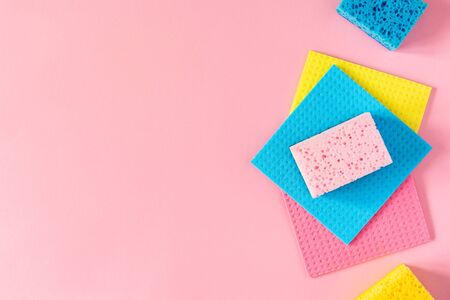 Multi-colored cloths and cleaning sponges on pink backgroundの写真素材