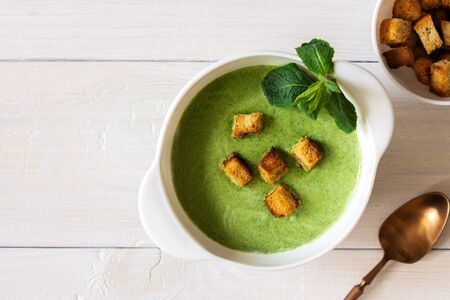 Delicious fresh cream soup of young peas and mint with croutons made of white bread, healthy foodの写真素材