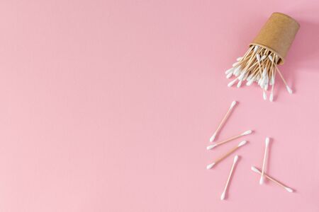 Wooden cotton swabs in an eco cup on a pink background, bath spa accessoriesの写真素材