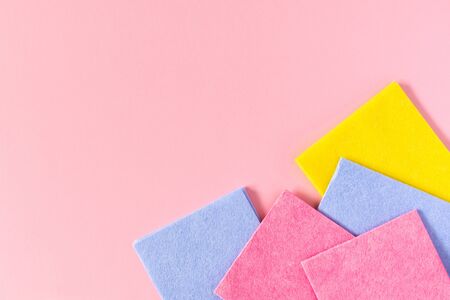 Multi-colored cloths on pink background, housekeeping and cleaning conceptの写真素材