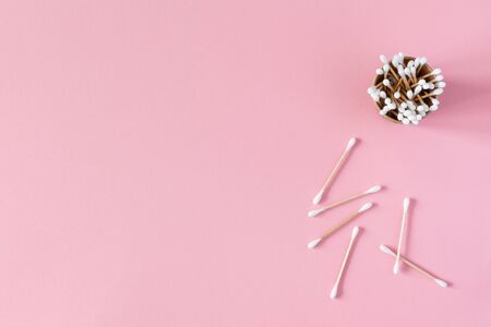 Wooden cotton swabs in an eco cup on a pink background, bath spa accessoriesの写真素材