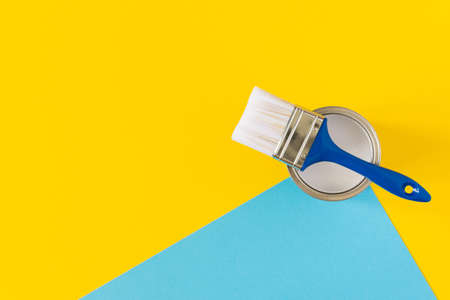 Can of white paint with a blue brush on colorful background, painting, top viewの写真素材