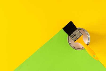 Can of white paint with a yellow brush on colorful background, painting, top viewの写真素材