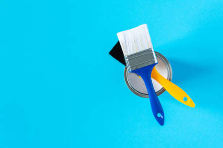 Can of white paint with brushes on a blue background, painting, top viewの写真素材