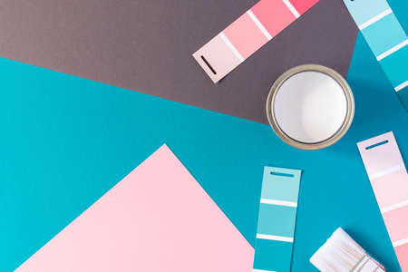 Can of white paint with brush on colorful background, selection of palette for painting, sample color catalog, top viewの写真素材