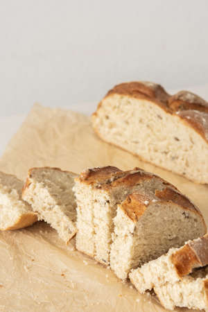 Loaf of homemade bread with sliced bread from wheat and seeds on parchment paperの写真素材