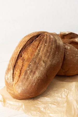 Loaf of homemade bread from wheat and seeds on parchment paper