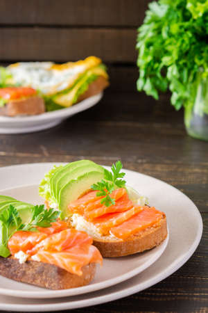 Different delicious sandwiches for breakfast, bread with cheese, avocado and trout, sandwich with egg and parsleyの写真素材