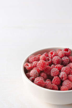 Raspberries close-up in bowls on a white background, ripe juicy berriesの写真素材