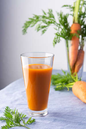 Natural carrot juice with pulp sugar-free in glasses on a table with a blue tableclothの写真素材