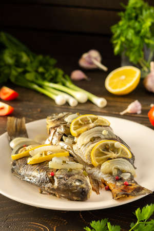 Baked carassius with lemon and spices in foil in the oven, cooked river fish crucian carpの写真素材
