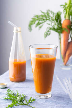 Natural carrot juice with pulp sugar-free in glasses on a table with a blue tableclothの写真素材