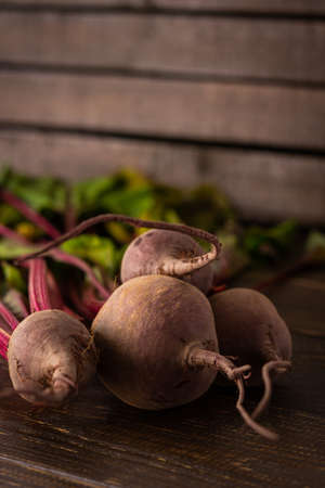 Fresh harvest beet, beet with green tops on brown wooden background close-upの写真素材