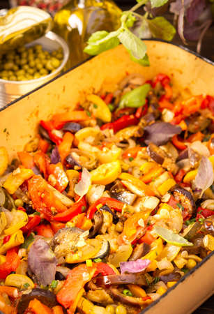 Stewed vegetables in an bowl, eggplant with zucchini and tomatoes, sweet and hot peppers and spices, mixing of Ratatouille ingredients in a bowlの写真素材