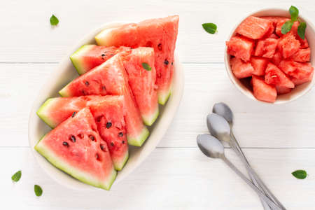 Juicy ripe sweet red watermelon slices with mint in a plate on a white background, top viewの写真素材