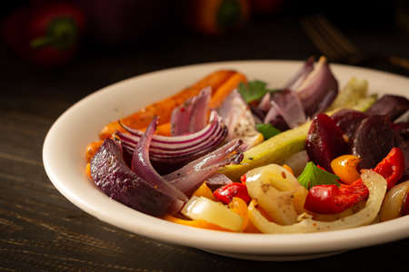 Stewed vegetables in a plate, carrots with garlic and red onions,zucchini with bell pepper and beetroot, sweet and hot peppers and spicesの写真素材