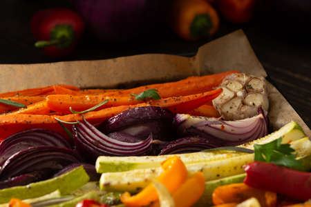 Stewed vegetables on a baking sheet, carrots with garlic and red onions,zucchini with bell pepper and beetroot, sweet and hot peppers and spicesの写真素材