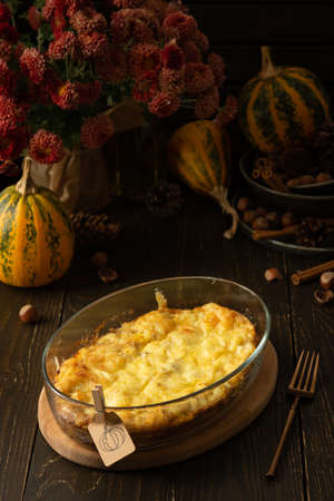Pumpkin frittata with mozzarella, omelette in a glass dish baked with cheese in the oven on a wooden backgroundの写真素材
