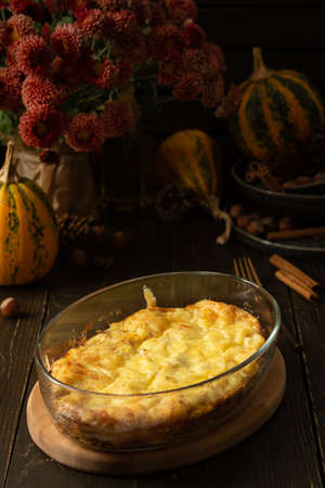 Pumpkin frittata with mozzarella, omelette in a glass dish baked with cheese in the oven on a wooden backgroundの写真素材