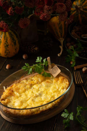 Pumpkin frittata with mozzarella, omelette in a glass dish baked with cheese in the oven on a wooden backgroundの写真素材
