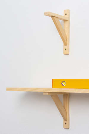 The process of fixing the wooden shelf to the wall, the level tool checks the evenness of the shelfの写真素材