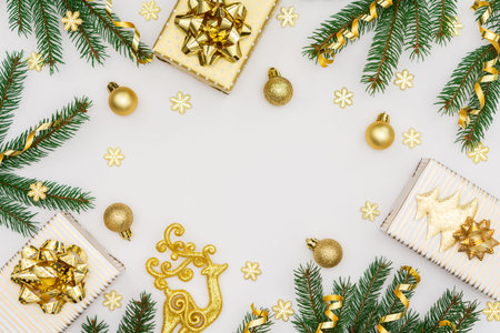 Festive background with gold decoration, green spruce branches and shiny golden serpentine confetti,...